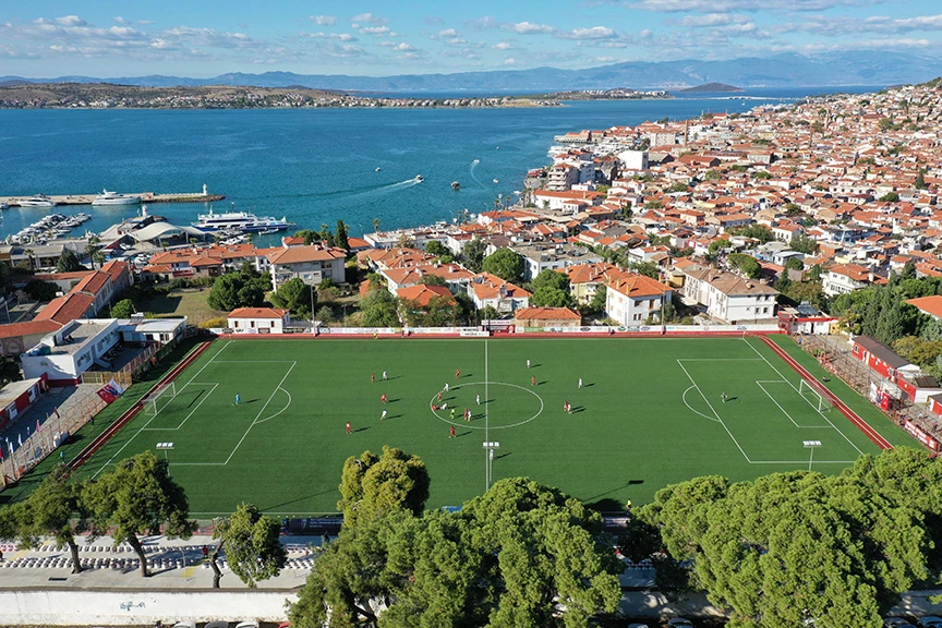 Ağaçların gölgesinde deniz manzaralı tribünde maç keyfi